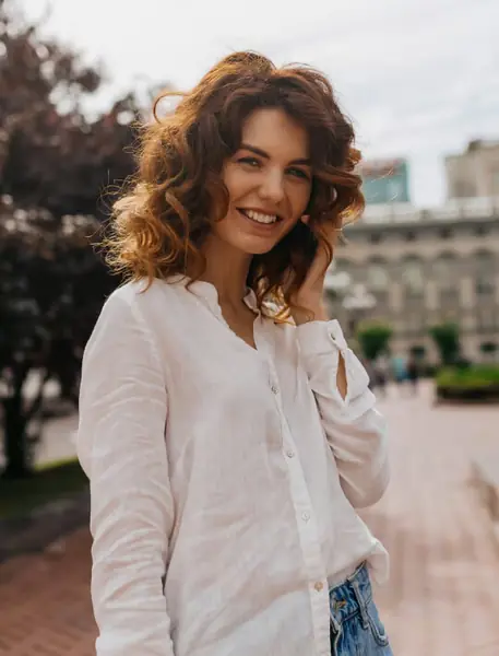 A smiling woman in a city setting for a MeetWild profile
